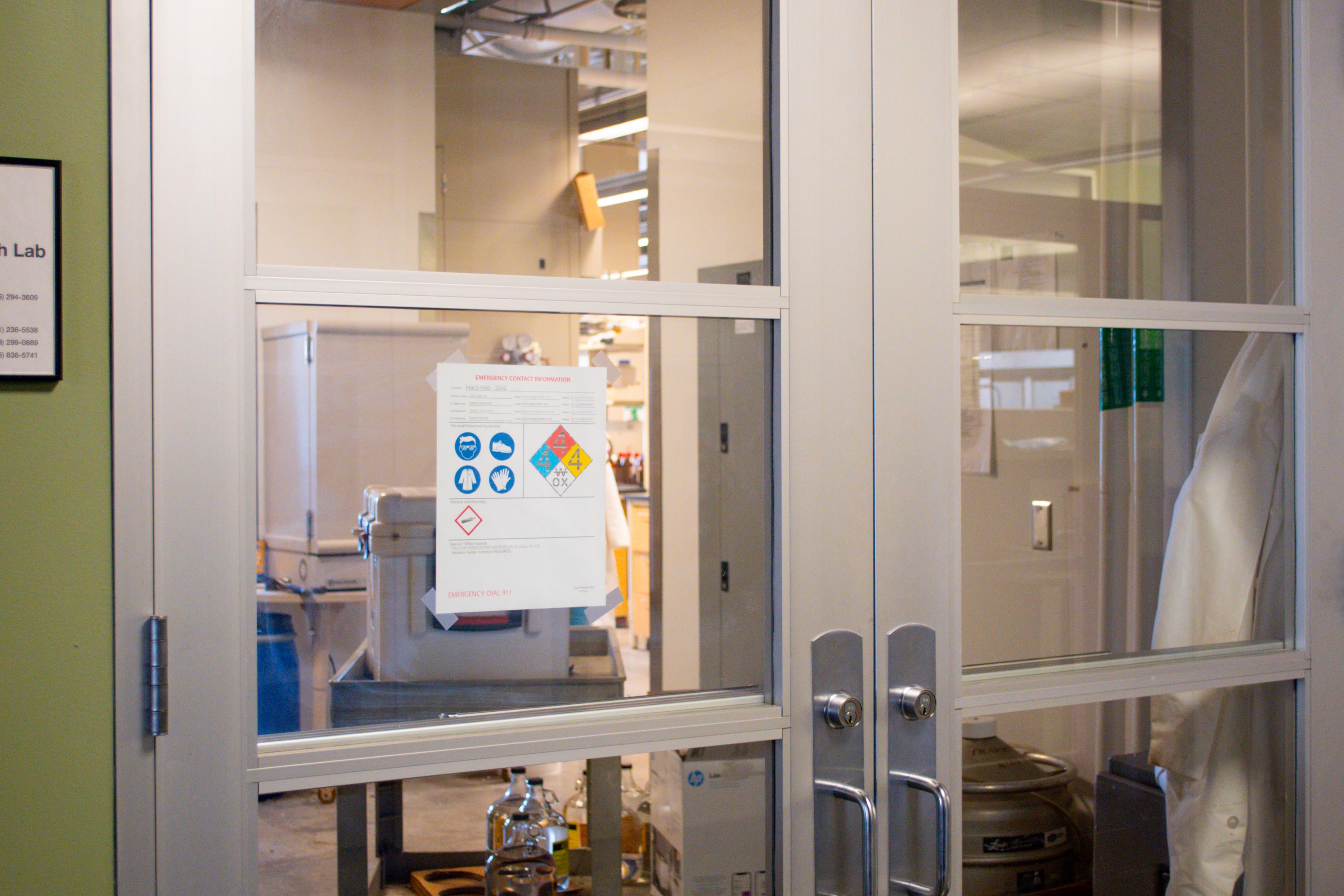 Photo of a research laboratory entrance with hazard communication sign posted on the door.