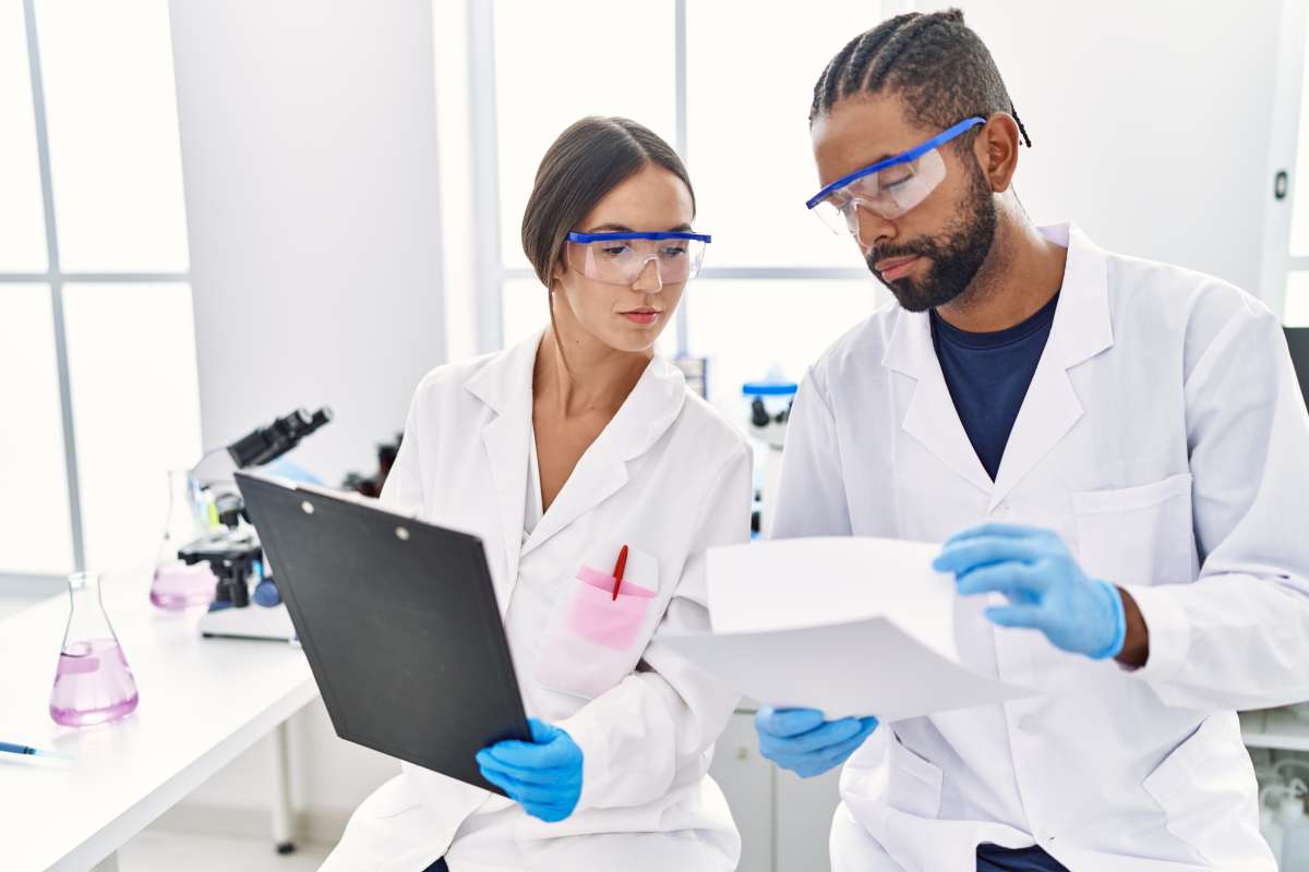 Two researchers reading documents in a laboratory