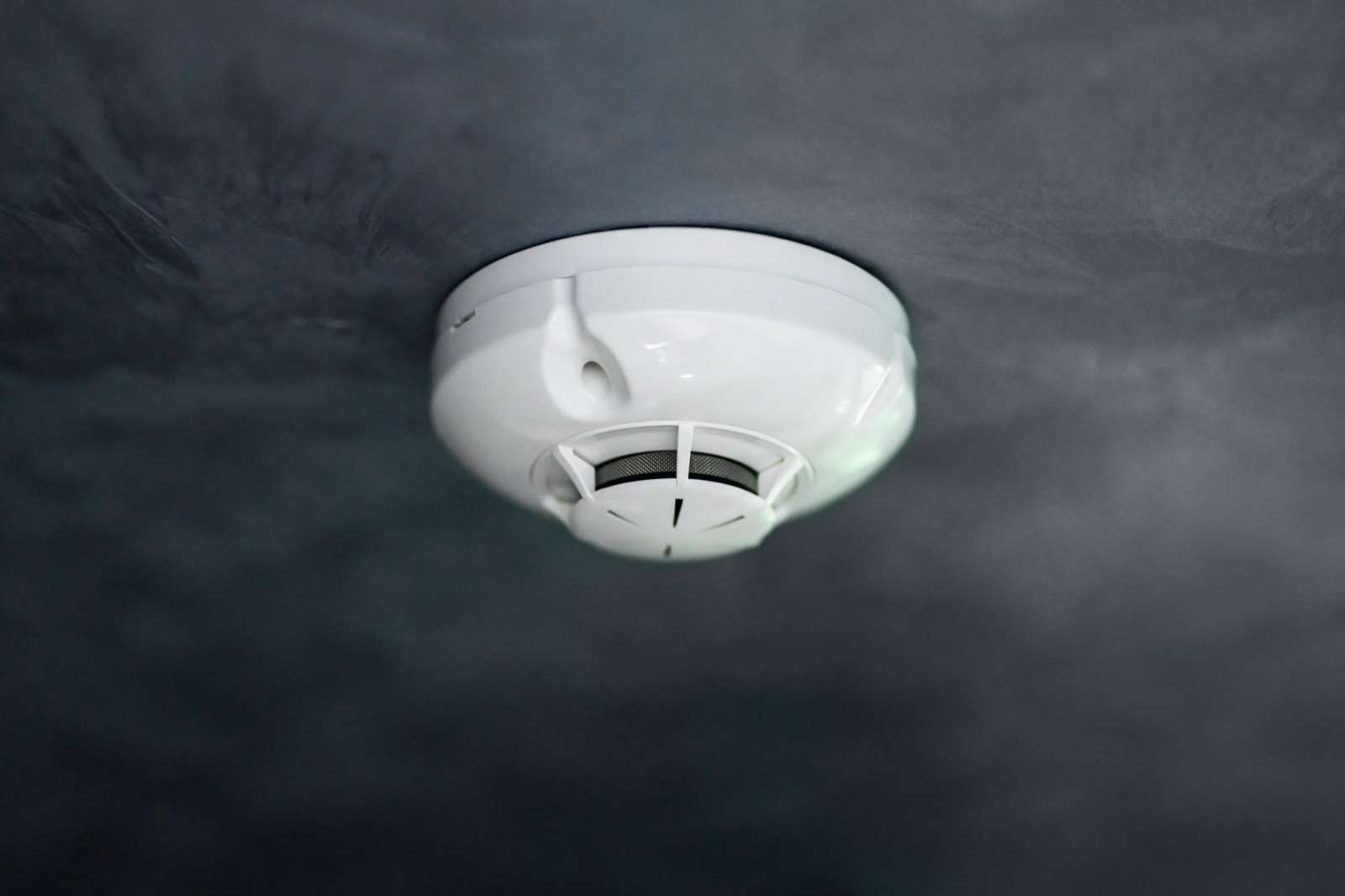 Photo of a carbon monoxide detector and a pollutant in the air