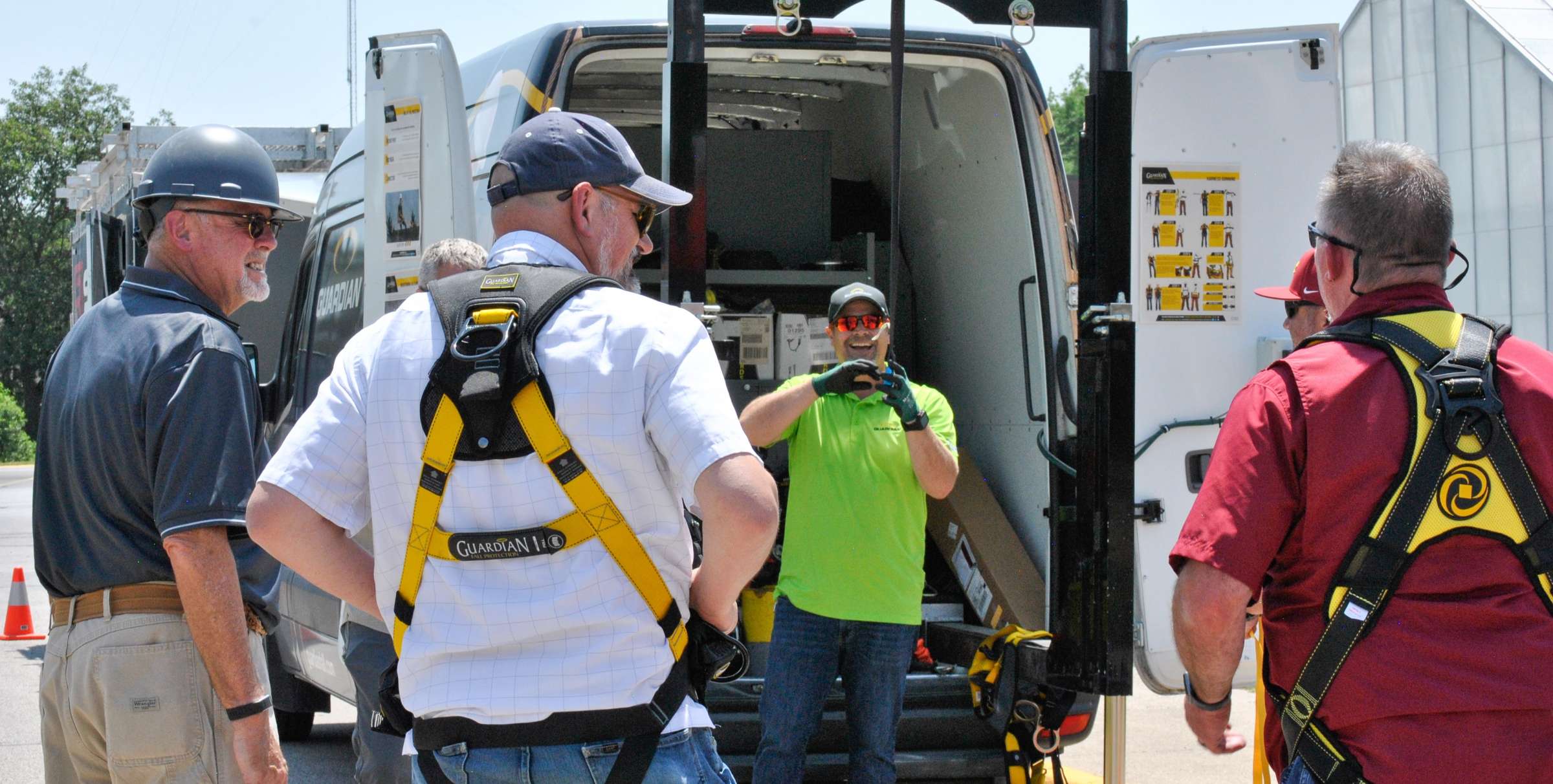 Participants try on fall protection harnesses during an in-person fall protection training course