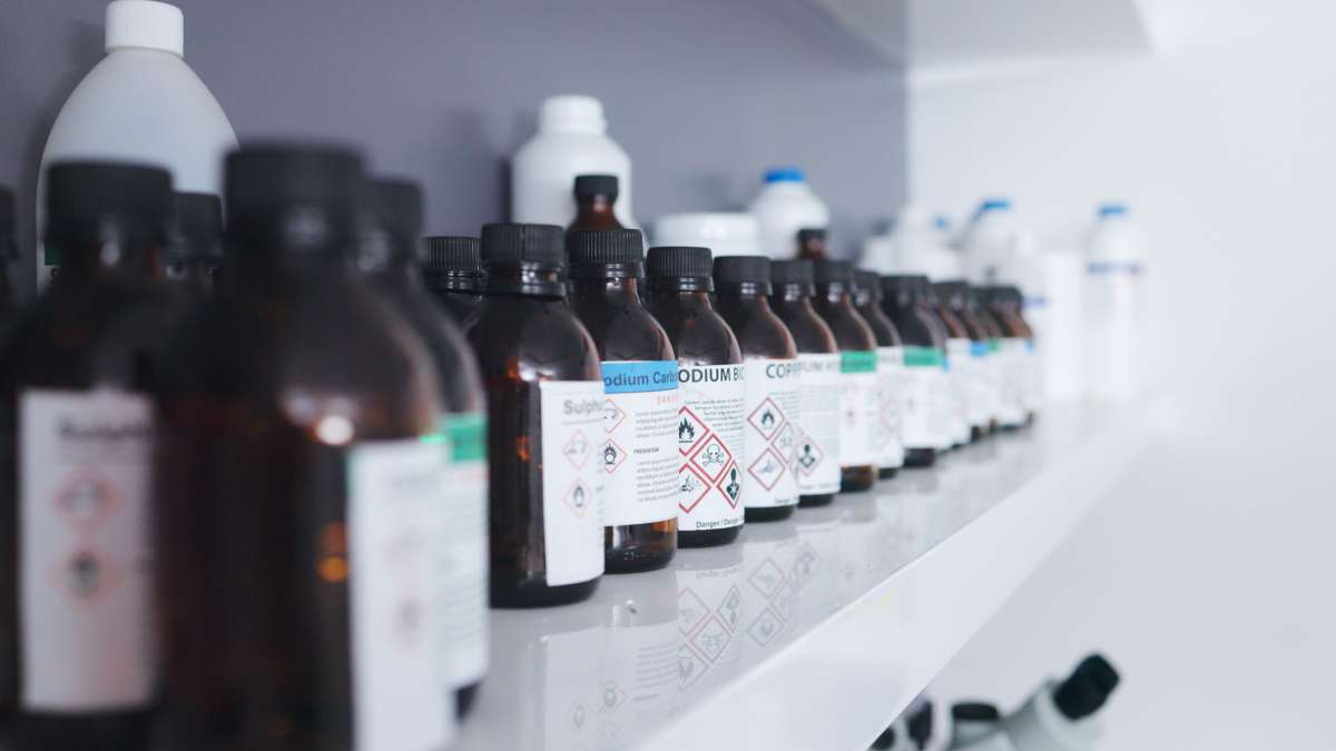 Several chemical containers lined up on a storage shelf