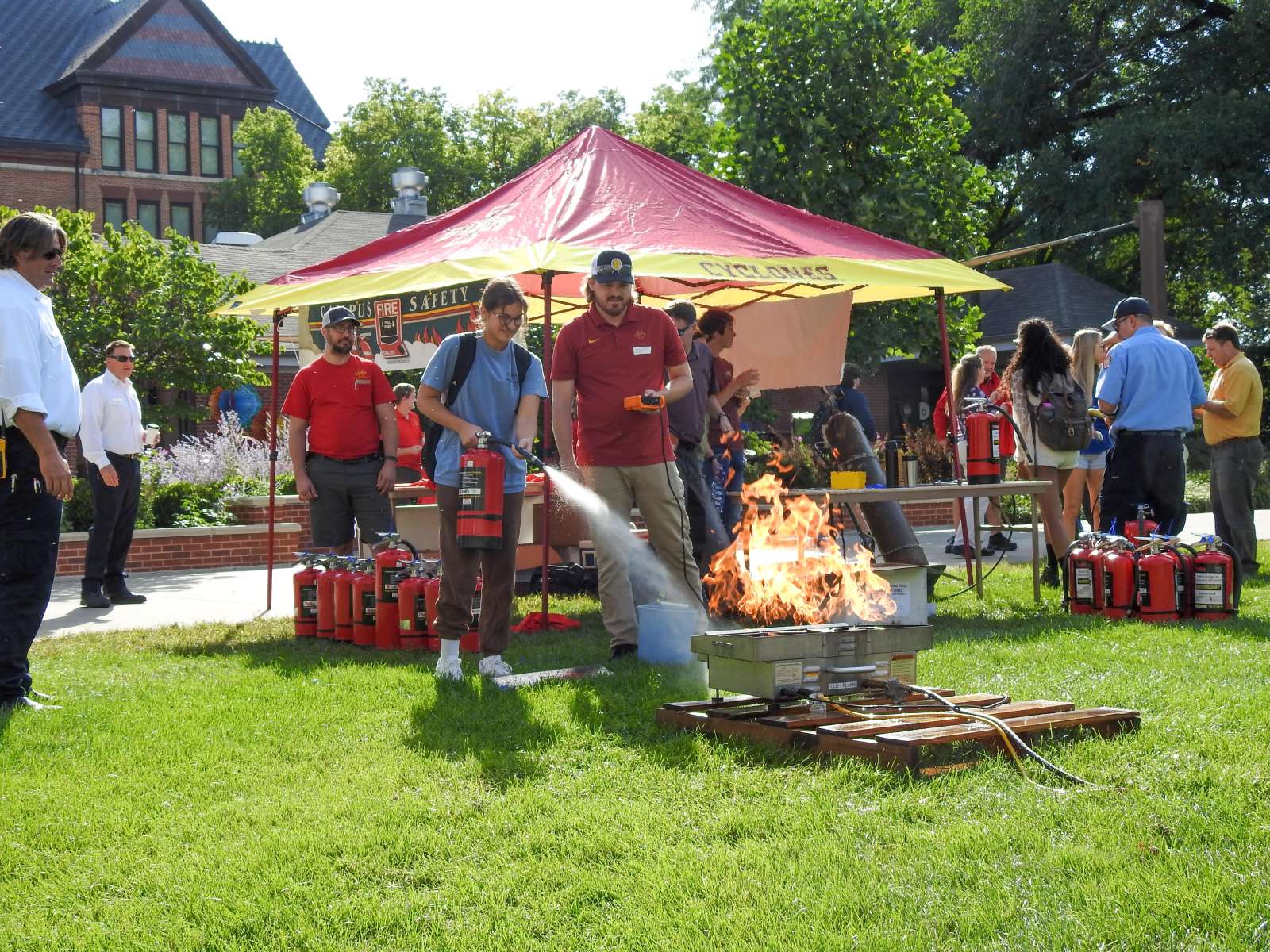 Photo of student extinguishing a simulated fire at an EH&S Campus Fire Safety Day on campus