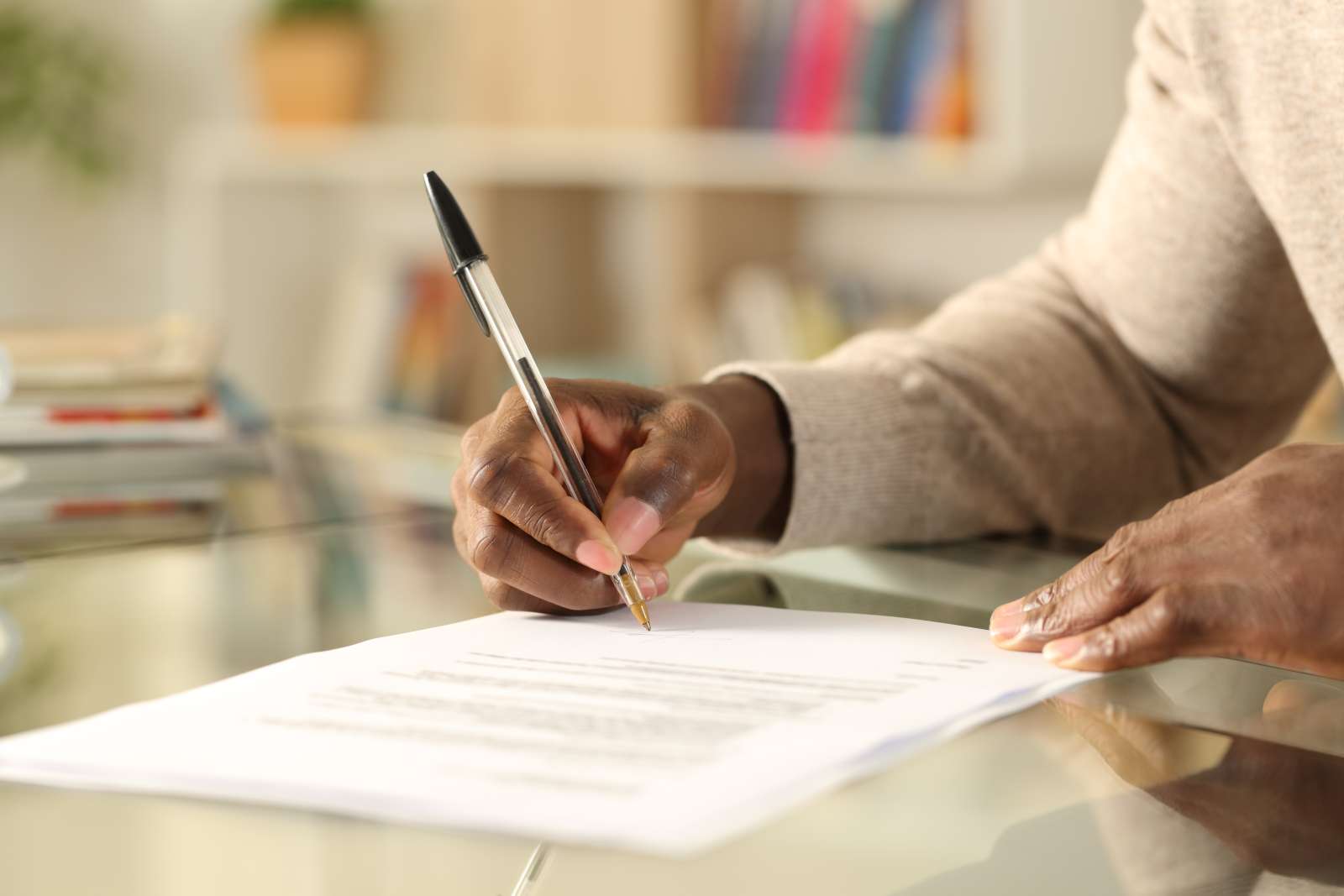 Person sitting at a table fills out a form